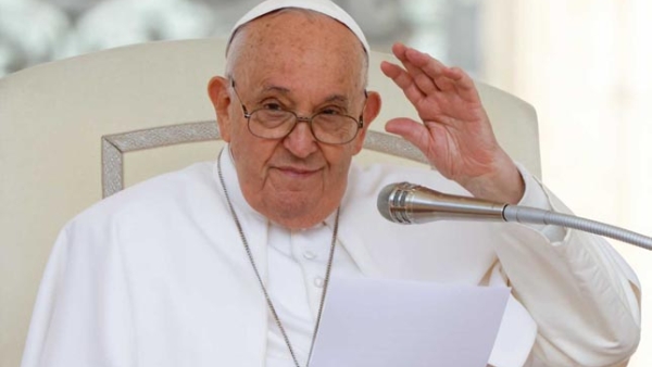 Pope Francis greets visitors as he speaks during his weekly general audience