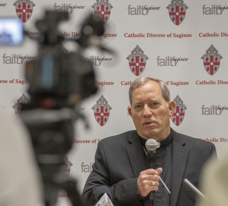 photo of bishop gruss holding a microphone at a press conference