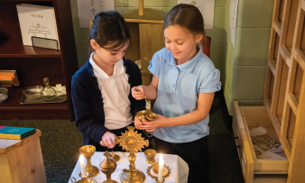 Tessa Phillips and Ella McCabe fill a tiny censer with incense in the Catechesis of the Good Shepherd Atrium