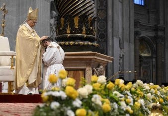 Pope Leo XIV lays his hands on the head of one of the 11 new priests 