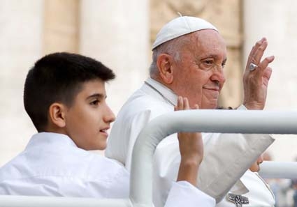 Pope Francis, and one of his young passengers in the popemobile