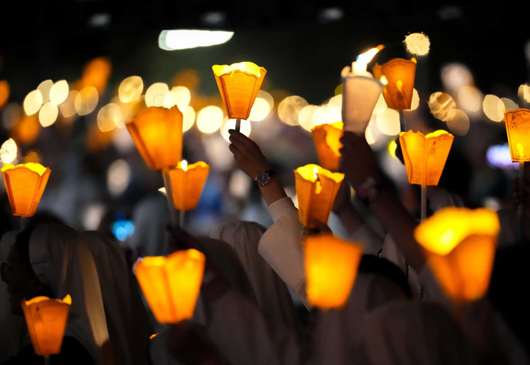 People carry candles during a torchlight procession 