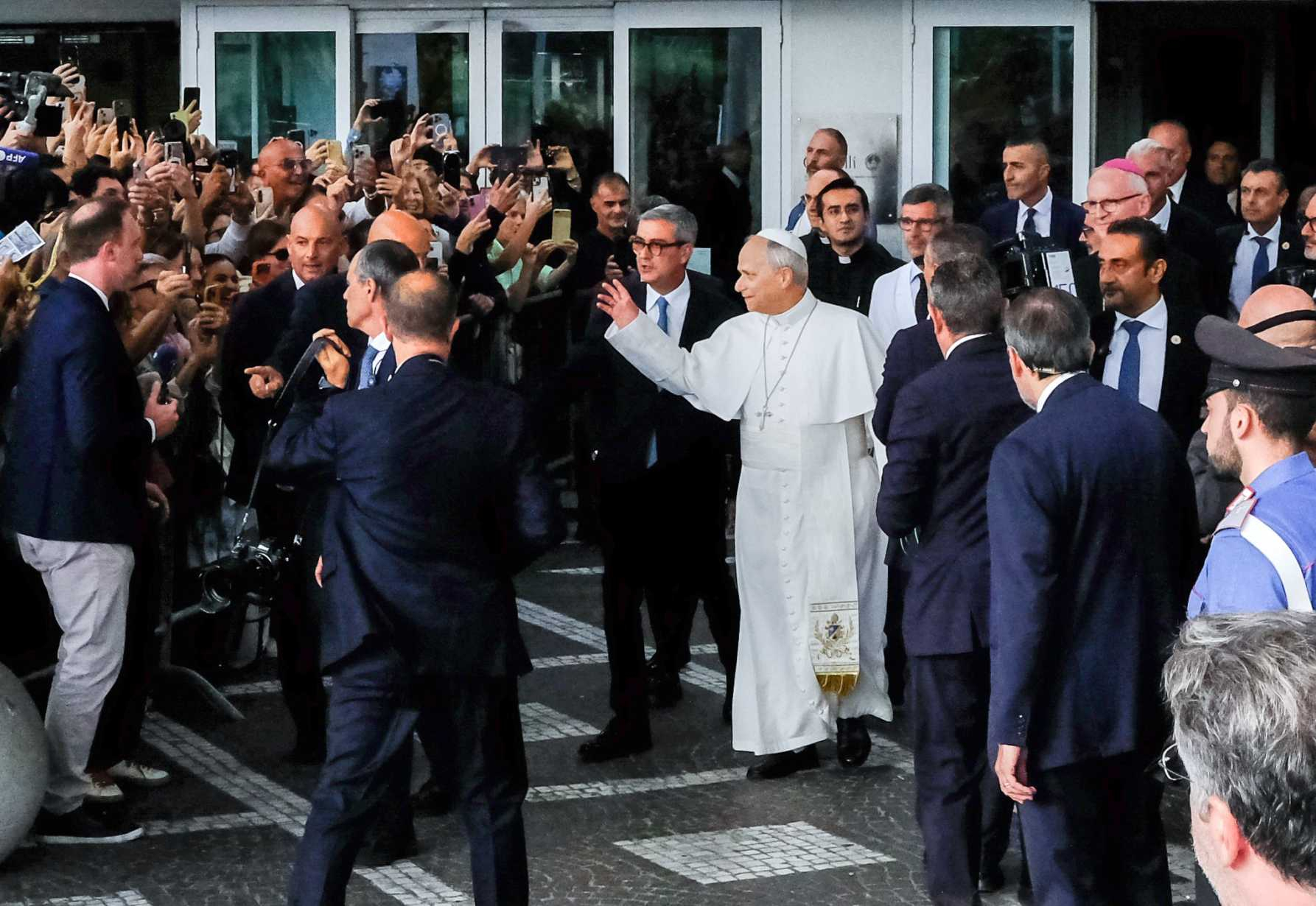 Pope Leo XIV waves to well-wishers as he walks out of Rome’s Gemelli hospital Oct. 17