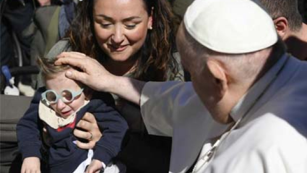 Pope Francis greets a child after his general audience in St. Peter's Square