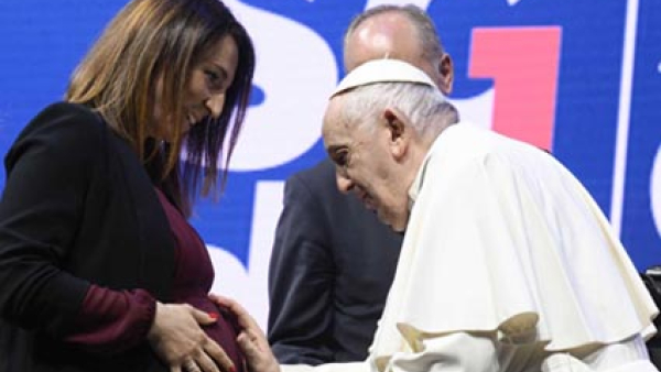 Pope Francis blesses a pregnant woman’s unborn child during a meeting about families 