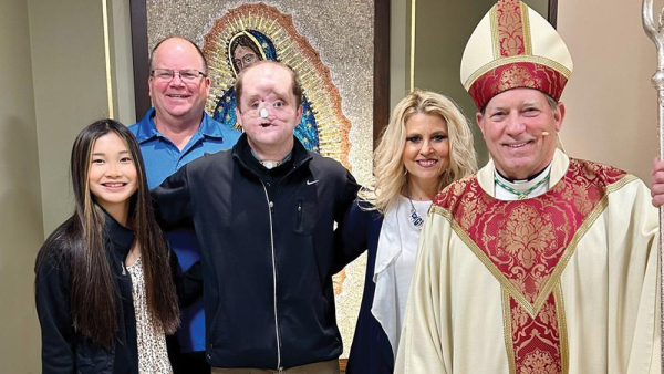 Derek Pfaff and family with Bishop Gruss