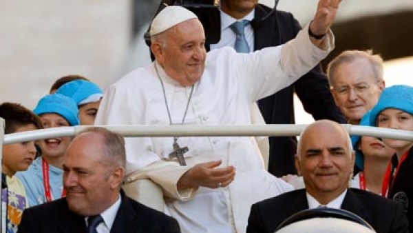 Pope Francis greets visitors from the popemobile as he rides around St. Peter's Square 
