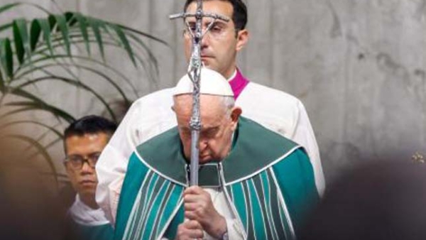 Pope Francis holds his crosier as the Gospel is read