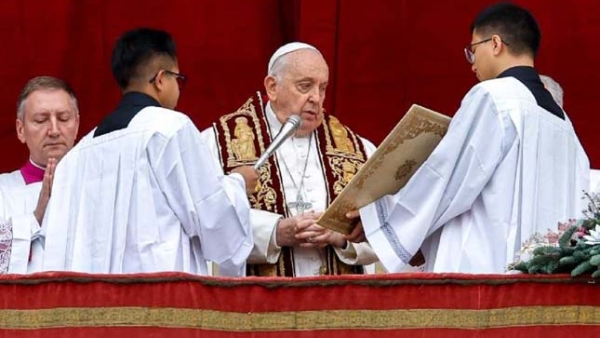 Pope Francis prays before giving his Christmas blessing