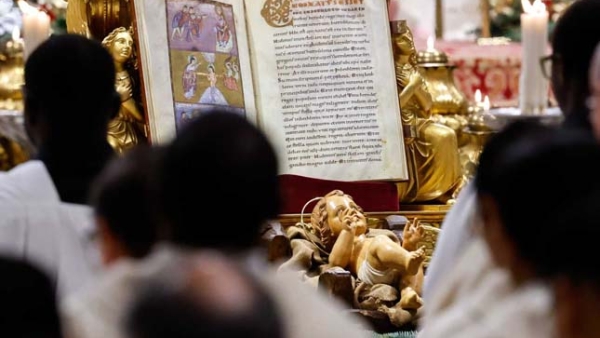 The Book of the Gospels and a statue of the baby Jesus rest in front of the main altar of St. Peter’s Basilica