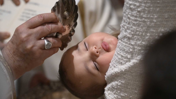 Pope Francis baptizes a baby during Mass in the Sistine Chapel