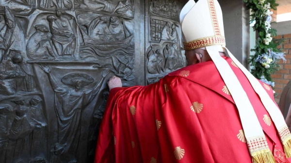 Pope Francis knocks on the Holy Door of the Church of Our Father at Rome's Rebibbia prison Dec. 26, 2024