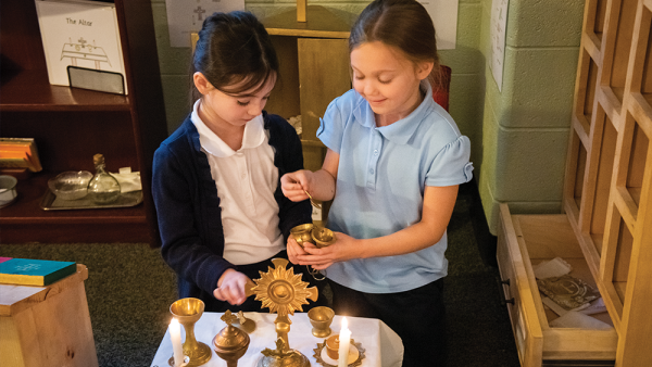 Tessa Phillips and Ella McCabe fill a tiny censer with incense in the Catechesis of the Good Shepherd Atrium