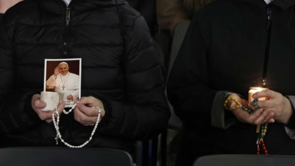 Religious sisters hold rosaries, candles and an image of Pope Francis as they listen to an audio message from him before praying the rosary for his health in St. Peter's Square at the Vatican March 6, 2025.