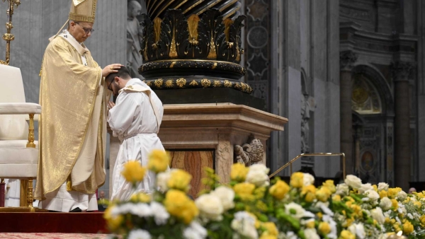 Pope Leo XIV lays his hands on the head of one of the 11 new priests 