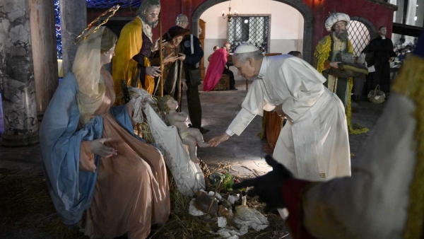 Pope Leo XIV touches a figurine of the baby Jesus