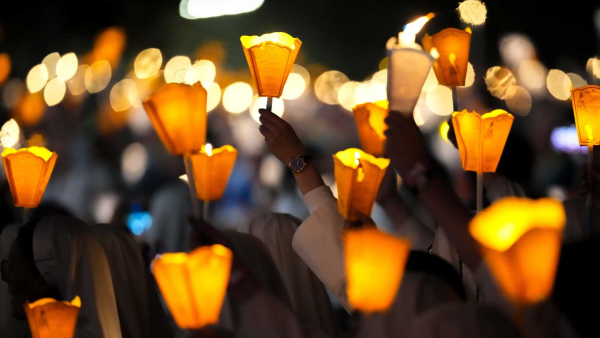 People carry candles during a torchlight procession 